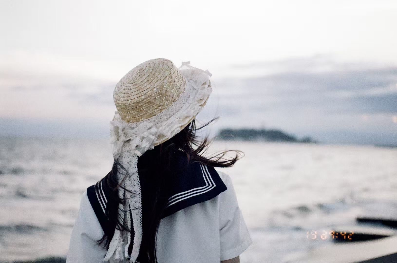 港のほうを見つめる青い後ろ姿